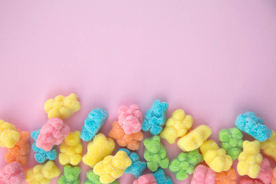 Deliciosos y coloridos osos osos de goma en un fondo de un fondo rosa
 - Foto, imagen