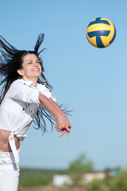 Woman playing volleyball on beach - 写真・画像