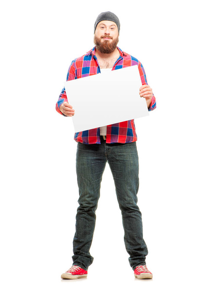 Cheerful bearded man holding blank and smiling at camera while standing isolated on white background - Photo, Image