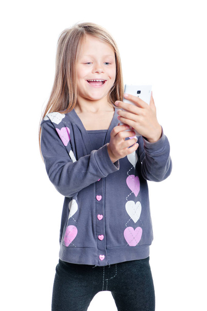 Cute little girl using smart phone isolated on white - 写真・画像