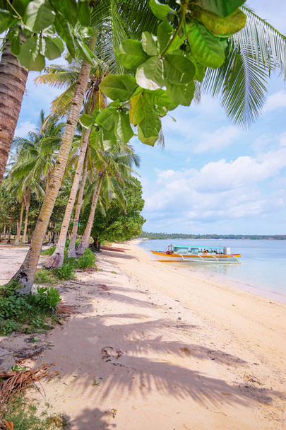 漁船と熱帯の白い砂のビーチと美しい景色。Siargao 島、フィリピン. - 写真・画像