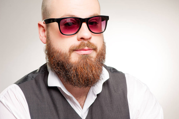  portrait of confident young man with a long beard in sunglasses, looking into the camera. - Foto, Imagem