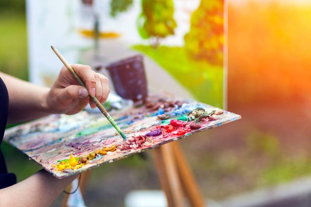 Ένα close-up καλλιτέχνης ζωγραφίζει πάνω σε καμβά ένα αστικό τοπίο ένα ανάχωμα καλοκαίρι με ευχαρίστησαν από ελαιοχρώματα - Φωτογραφία, εικόνα