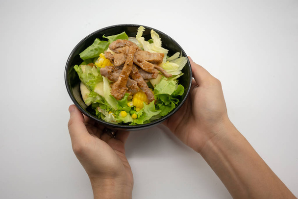 Hand serviert hausgemachtes gegrilltes Schweinefleisch mit Bio-grünem Gemüse isoliert auf weißem Hintergrund. - Foto, Bild