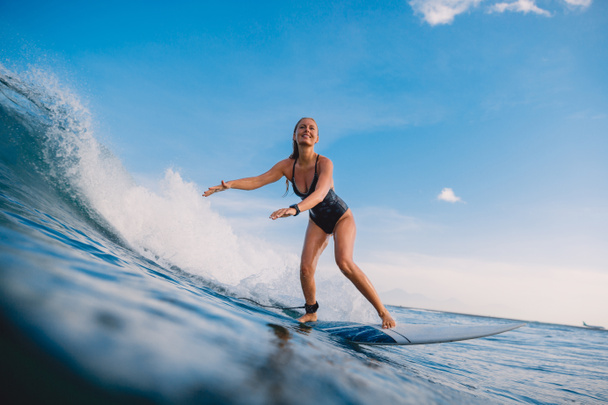 Surf kobieta o deska surfingowa jazdy na fali. Kobieta w oceanie podczas surfowania. Surfer i ocean - Zdjęcie, obraz