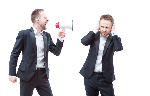 Bearded businessman shouting with megaphone shouting at him self, clone or twin, who covering ears with hands while standing isolated on white background. - Fotografie, Obrázek