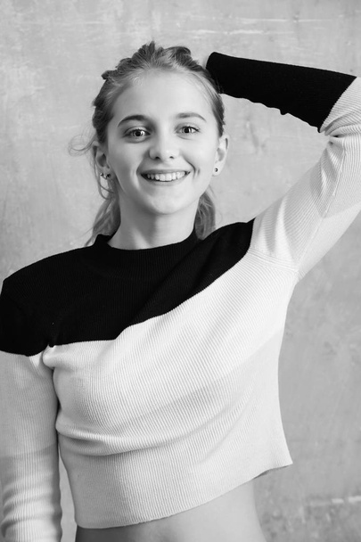 young girl smiles. happy beautiful young girl, fashionable teen on beige background - Фото, изображение