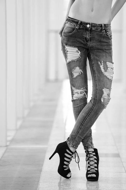 girl in ragged jeans. fashionable young girl with long legs wearing blue jeans, shoes - Foto, Imagem