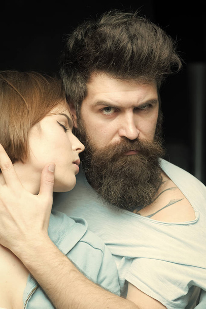 Woman on mysterious face with bearded man, black background. Fashion shot of couple after haircut. Barbershop concept. Man with stylish beard and mustache and girl with fresh haircut, new hairstyle - 写真・画像
