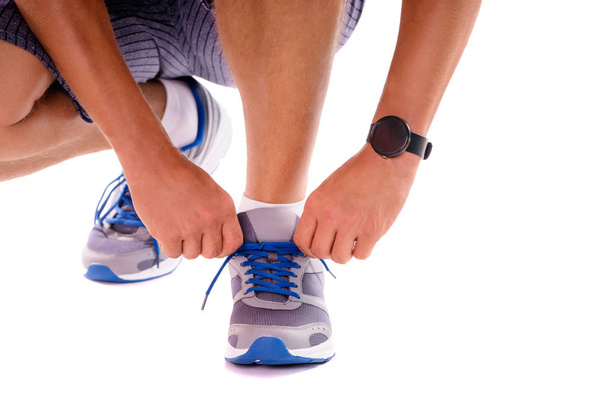 Close up of male hands with smartwatch tying sneakers - Φωτογραφία, εικόνα
