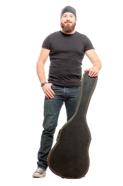 Full length shot of trendy young man posing with guitar case over white background isolated - Foto, afbeelding