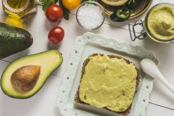 Verse Avocado verspreiding Guacamole als gezond ontbijt op witte Bac - Foto, afbeelding