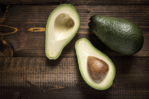 Sağlıklı gıda kavram olarak koyu ahşap arka plan üzerinde avokado - Fotoğraf, Görsel