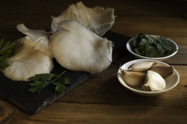 Thistle syrové houby na břidlicové desky, mísy česnek a petržel mísa na dřevo stůl - Fotografie, Obrázek