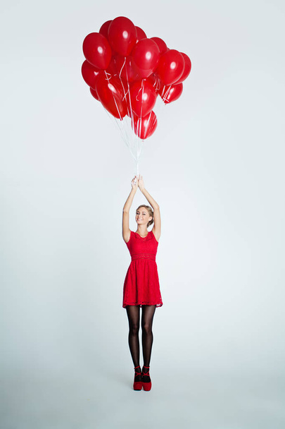 Модель моды Happy Woman с красными воздушными шарами, праздничный фон
 - Фото, изображение