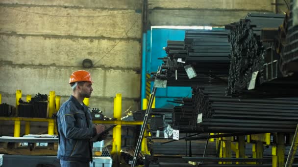 Gebaarde mannelijke fabriek manager werken in het magazijn voor de metaalbewerking - Video
