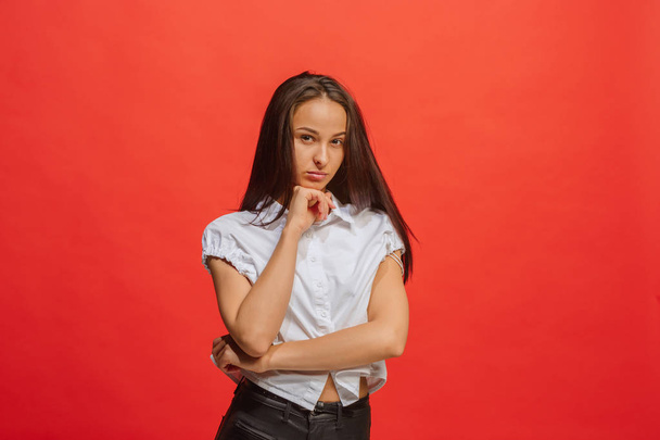 The serious business woman standing and looking at camera against red background. - Foto, imagen