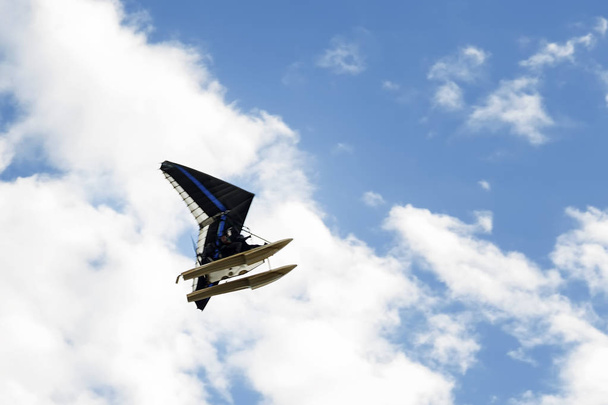 Motorizzato deltaplano vola altamente nel cielo con le nuvole
 - Foto, immagini