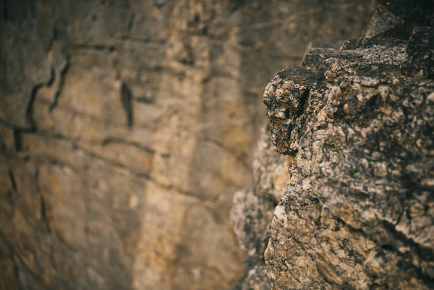 selective focus of surface of rocky cliff on blurred background - Foto, immagini
