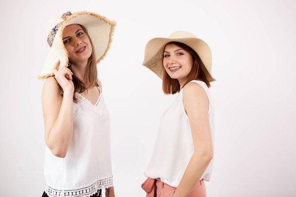 Two happy female friends wearing summer hats - Foto, Bild