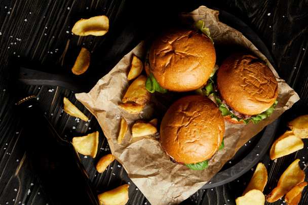 Top view of hamburgers and french fries served on craft paper - Photo, Image