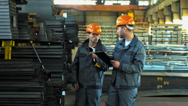 Trabajadores metalúrgicos profesionales trabajando juntos en el almacén de la fábrica
 - Metraje, vídeo