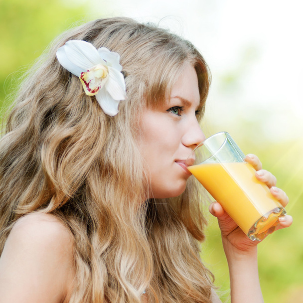 Smiling woman drinking orange juice - Foto, afbeelding