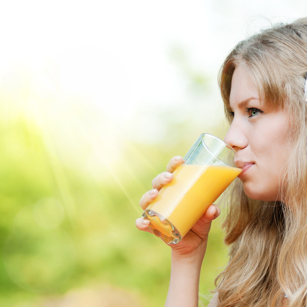 Smiling woman drinking orange juice - Fotó, kép