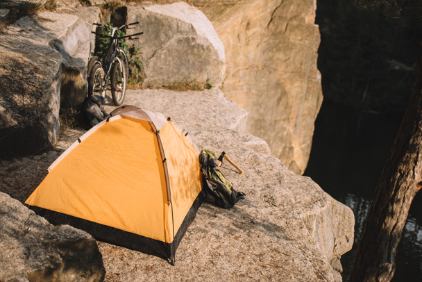 camping tent with trial bikes and backpack on beautiful rocky cliff - Photo, Image