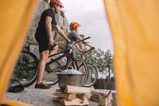 näkymä urheilullinen oikeudenkäynti moottoripyöräilijät kivinen kalliolla ulkona camping teltta
 - Valokuva, kuva