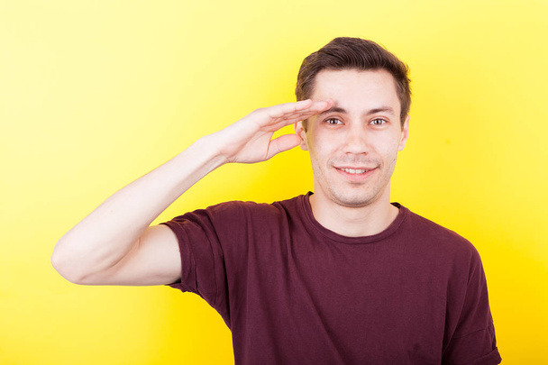 Man with his hand to the forehead making the army salute sign - Photo, image