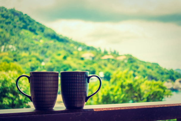 Gorący Coffee cup, z pięknym widokiem na tropikalną roślinność odkryty dla relaksu i wypoczynku - Zdjęcie, obraz