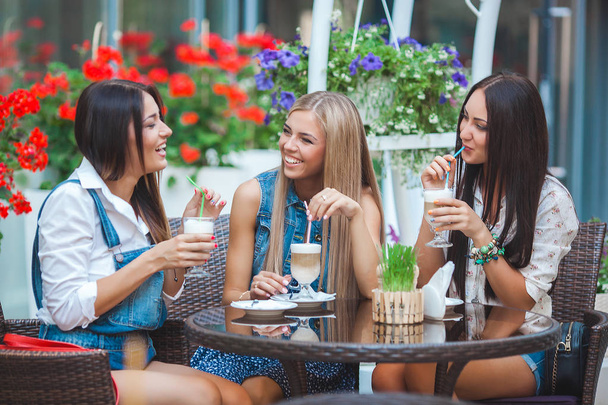 Group of girlfriends talking at the cafe with coffee - Photo, Image