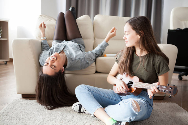 Two sisters in the living room having fun - Photo, Image