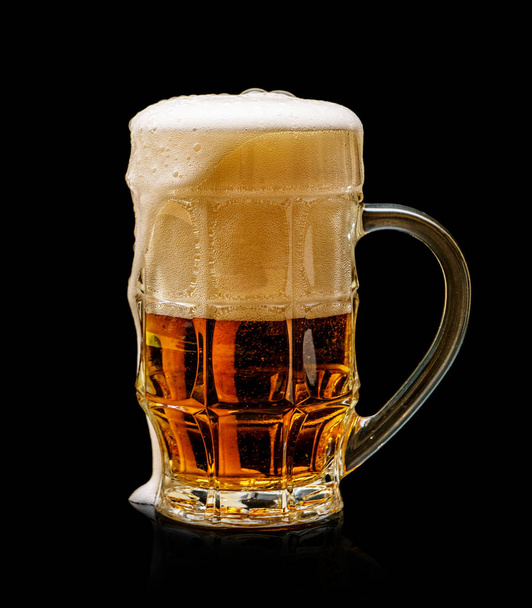 Glass beer mug with foam isolated on black background. - 写真・画像