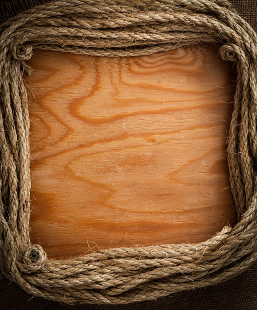 touwen frame met lege houten oppervlak als achtergrond  - Foto, afbeelding