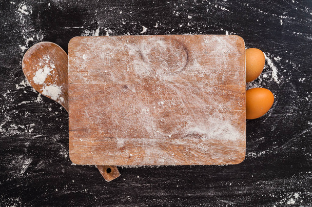 cutting board with wooden kitchenware on smeared out flour background - Фото, изображение
