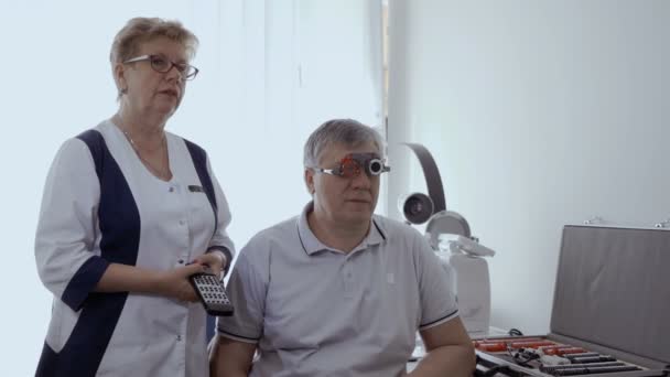 Doctor check mans sight with optical trial frame. Senior man has a bad eyesight and check it in ophthalmologist in modern clinic. - Filmmaterial, Video