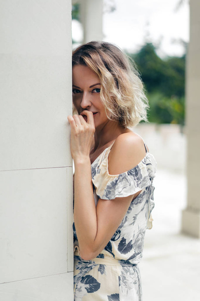 portrait of attractive blond woman in dress standing at villa terrace - Foto, immagini