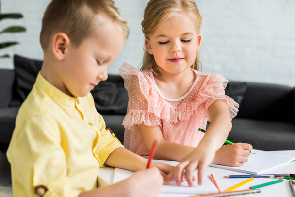 adorable siblings drawing with colored pencils at home - Photo, Image