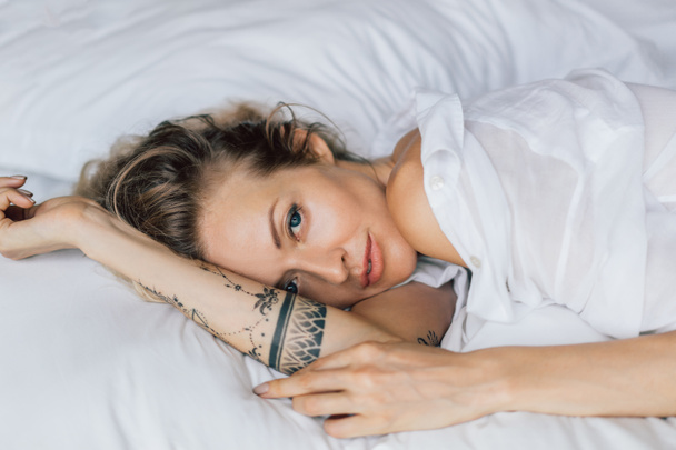 retrato de hermosa mujer rubia en camisa blanca descansando en la cama
 - Foto, Imagen