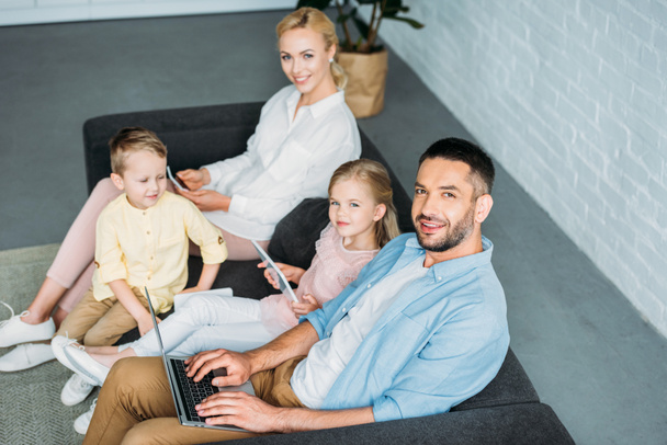 high angle view of happy family using digital devices and smiling at camera - Fotoğraf, Görsel