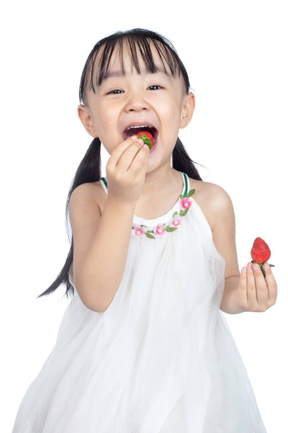 Asian Little Chinese Girl Eating Strawberry in isolated white background - Fotó, kép