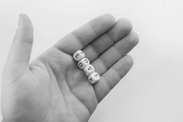 male hand holding dices with word love - Foto, Bild