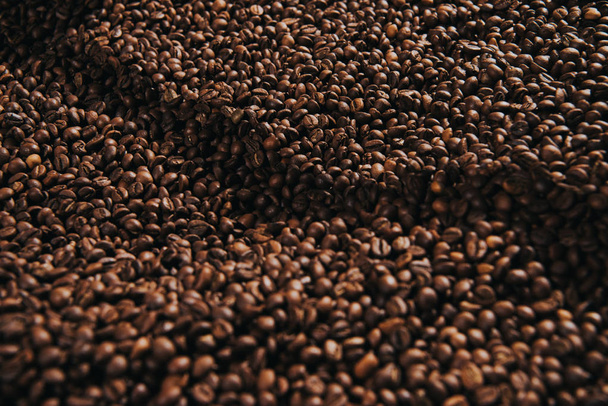 Close-up beeld van koffiebonen gebrand in professionele machine - Foto, afbeelding
