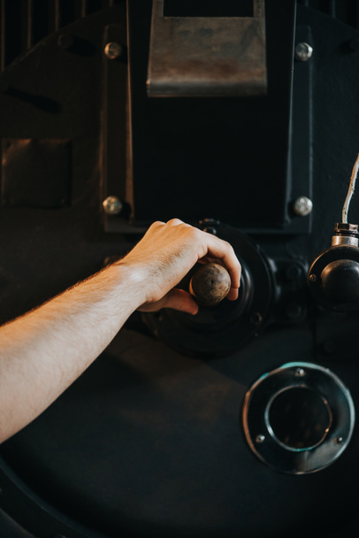 Mannenhand handvat van machine voor professionele koffieproductie aan te passen - Foto, afbeelding