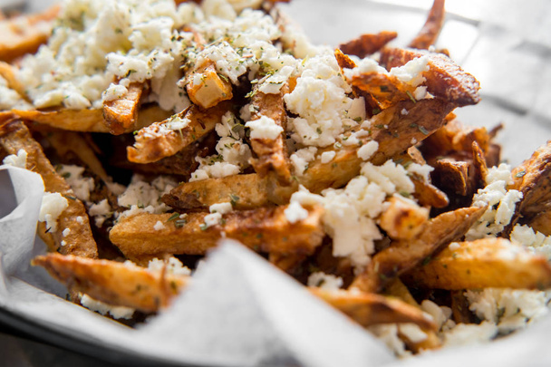 Delicious Mediterranean street cart fried potatoes with feta cheese herbs and spices - Photo, Image