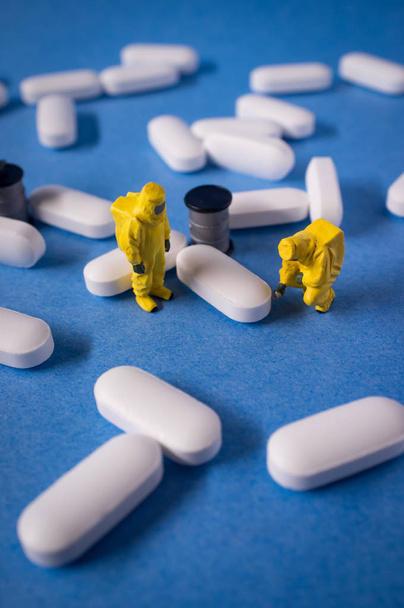 Miniatyyri hazmat joukkue tarkastaa vaarallisia kipulääkkeitä pillereitä
 - Valokuva, kuva