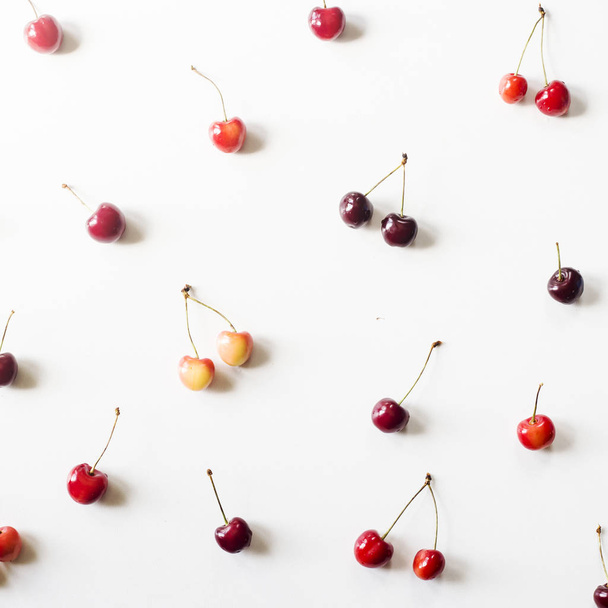 Yellow and dark red berries of a sweet cherry on a white background. Summer Pattern. Top view, flat lay - Фото, зображення