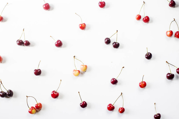 Yellow and dark red berries of a sweet cherry on a white background. Summer Pattern. Top view, flat lay - Фото, зображення